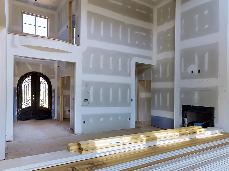 A tall boarded room with coffered ceiling detail and arched openings