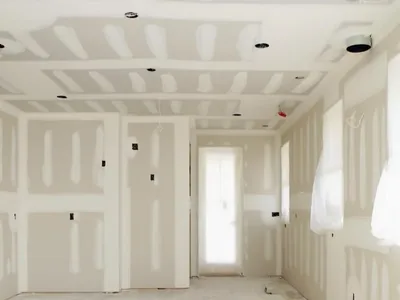 Drywall installation in a room boarded out with a stepped ceiling detail and recessed light cut-outs