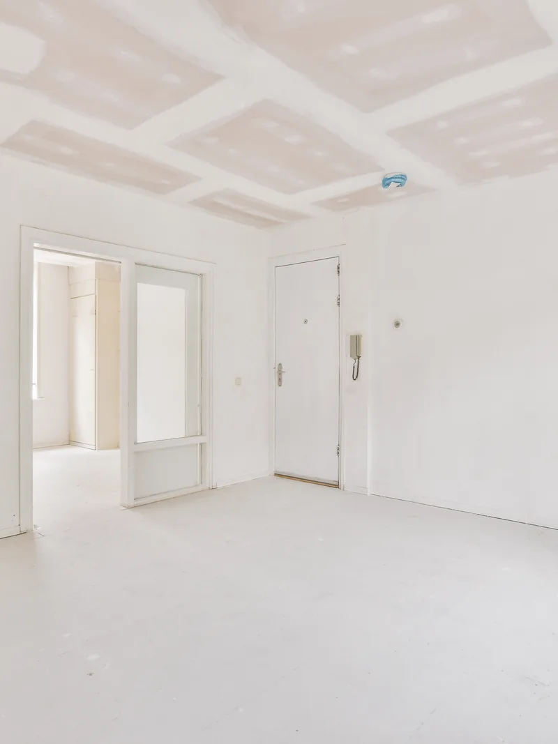 An empty room with plain white walls and ceiling and no trim yet