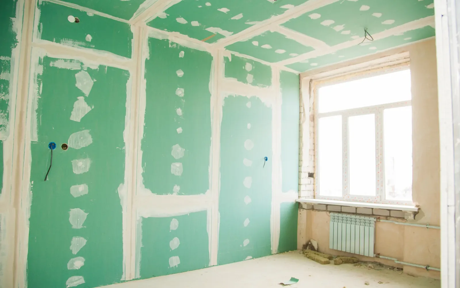 A room lined throughout in green moisture-resistant drywall after a flood rebuild