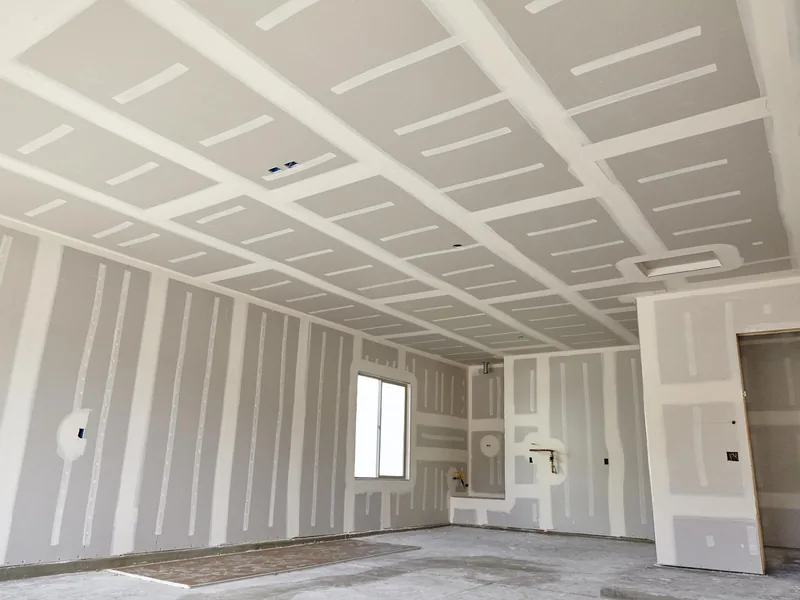 A large room with every drywall seam taped and mudded under a raised ceiling tray