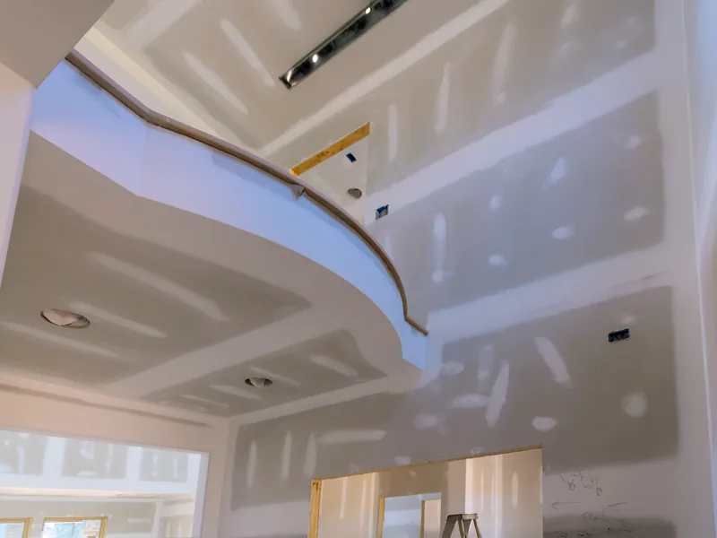 A vaulted ceiling taped out with one length of drywall tape still hanging loose