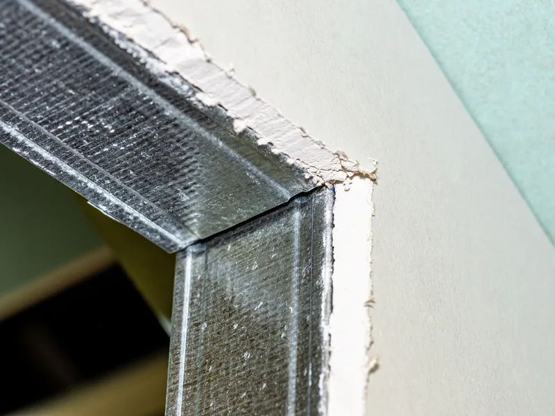 The cut corner of green moisture-resistant board fixed to an aluminium frame