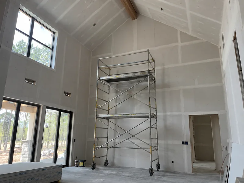 Mobile staging set against a two-storey interior wall under a vaulted ceiling