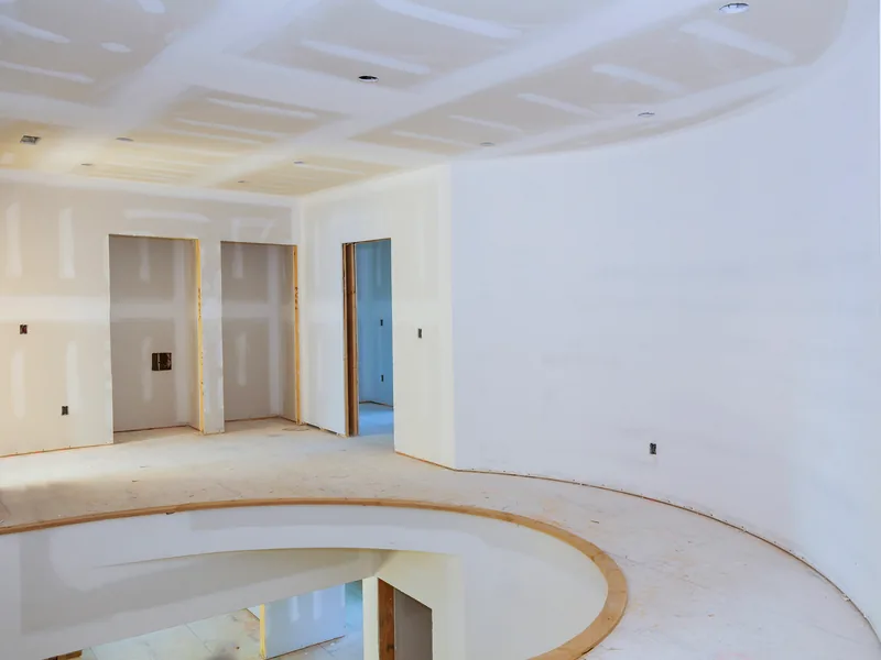 A curved wall sweeping round beneath a coffered ceiling, custom work in finished board